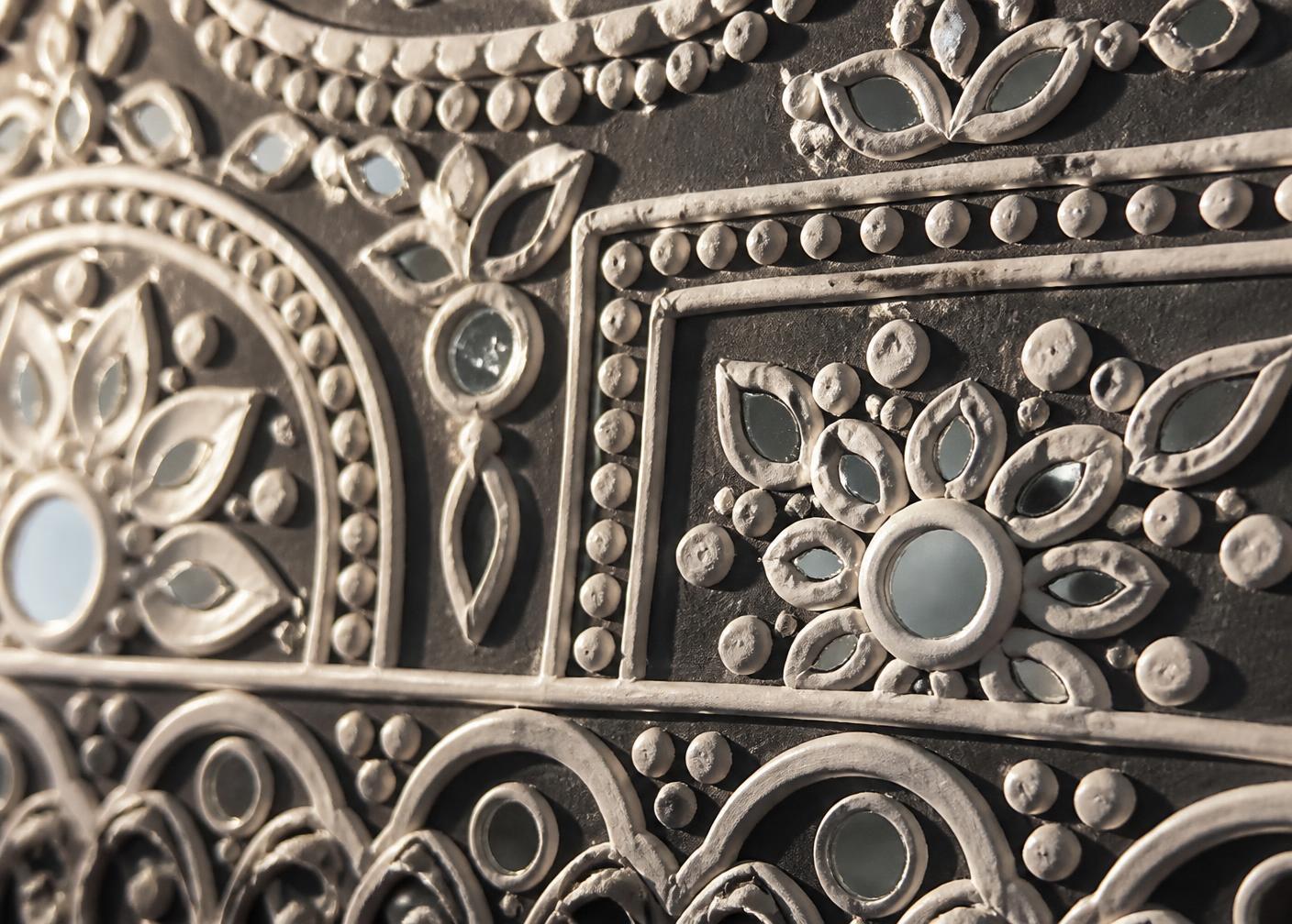 Macro detail of clay relief and mirror inlay in a Lippan artwork